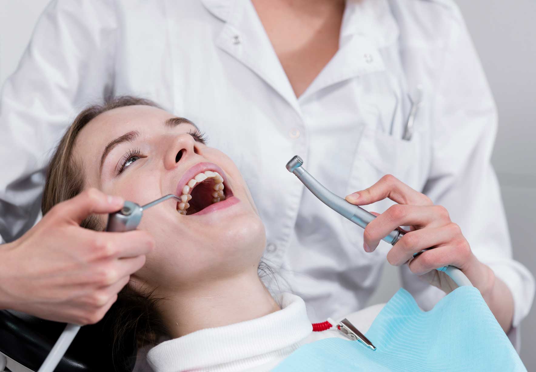 Dentista haciendo limpieza a paciente con instrumento