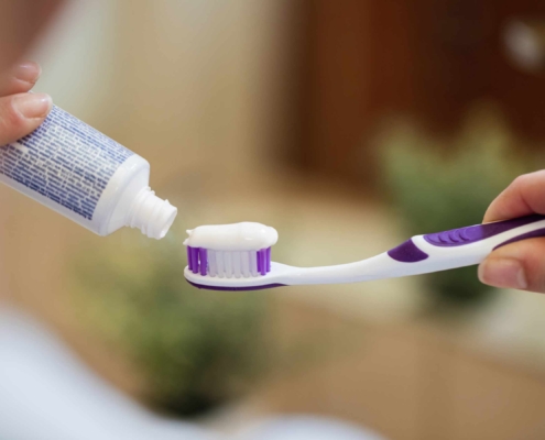 Mujer aplicando pasta de dientes en su cepillo