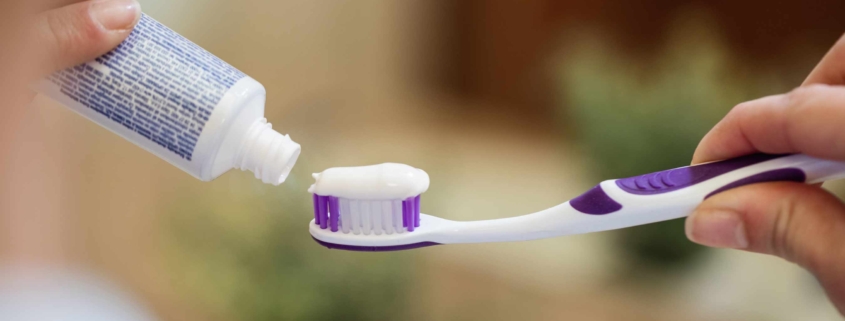 Mujer aplicando pasta de dientes en su cepillo