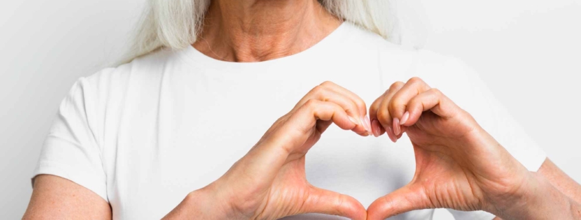 Mujer sonriendo haciendo un corazón con las manos