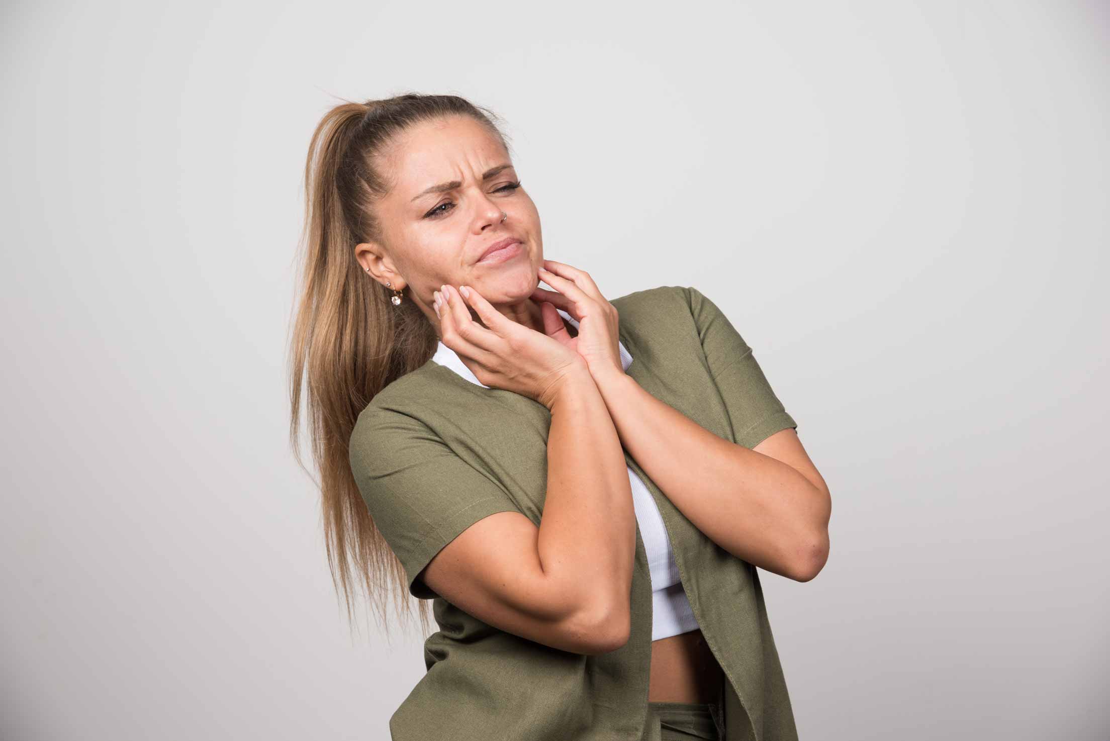 Mujer joven con dolor de mandíbula a causa del bruxismo