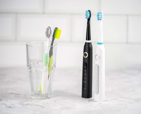 Diferentes tipos de cepillos de dientes: dos cepillos de dientes convencionales frente a dos cepillos de dientes eléctricos