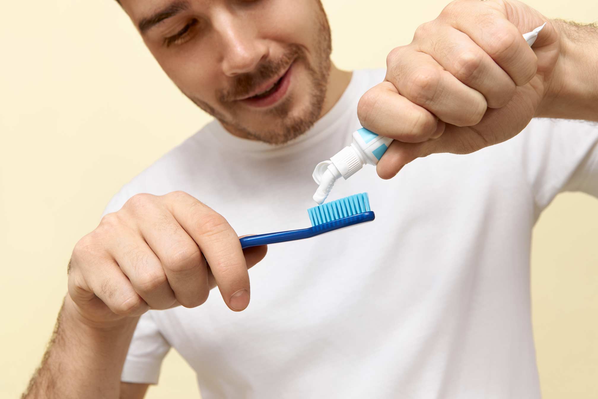 Hombre poniendo dentífrico en cepillo de dientes